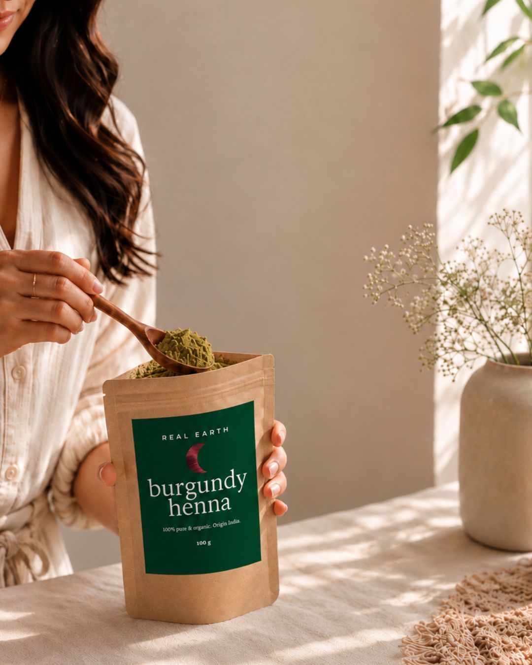 Mujer con cabello castaño oscuro tocándose la raíz antes de teñir con barros naturales Real Earth